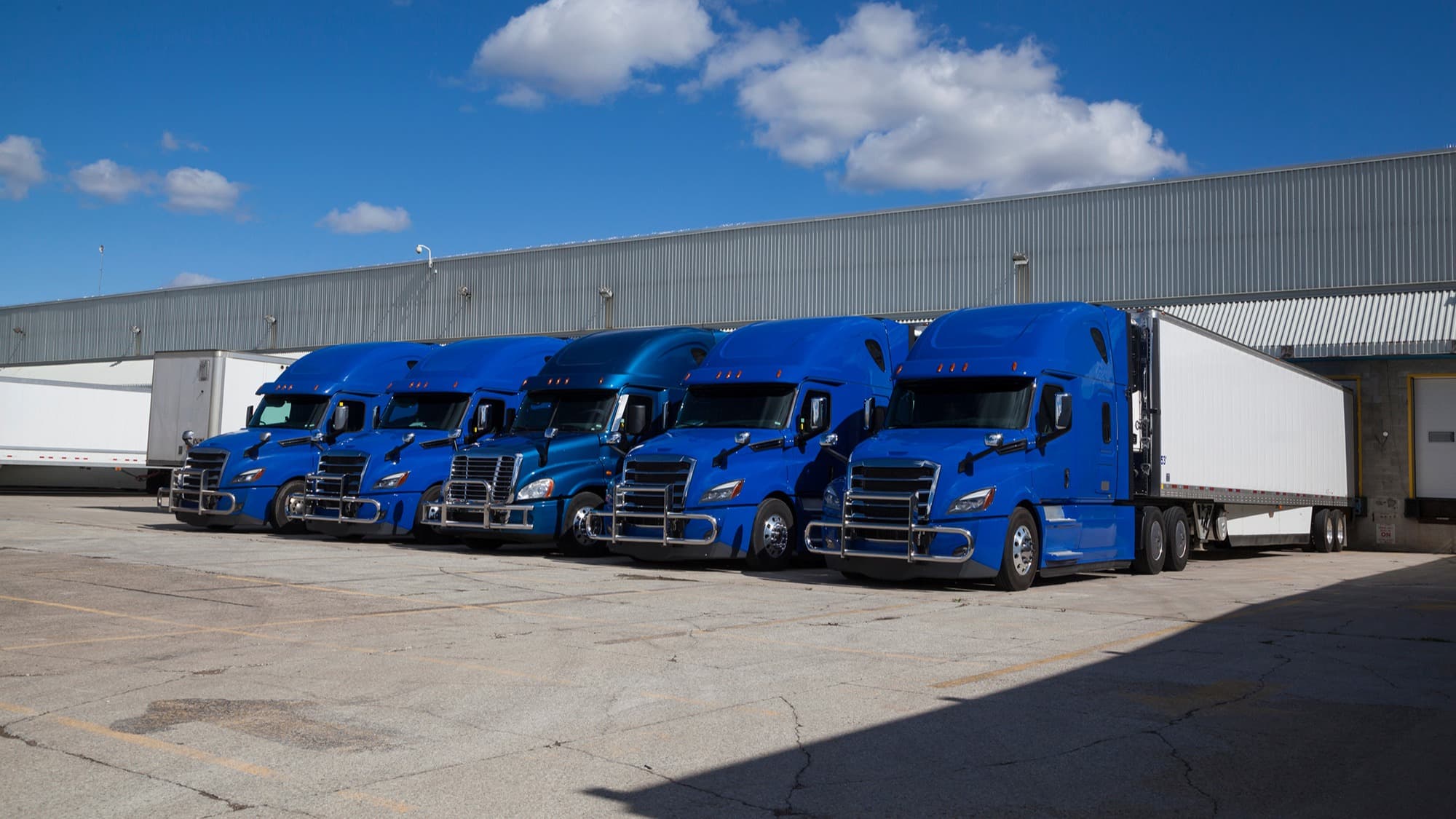 Trucks parked next to each other at a warehouse